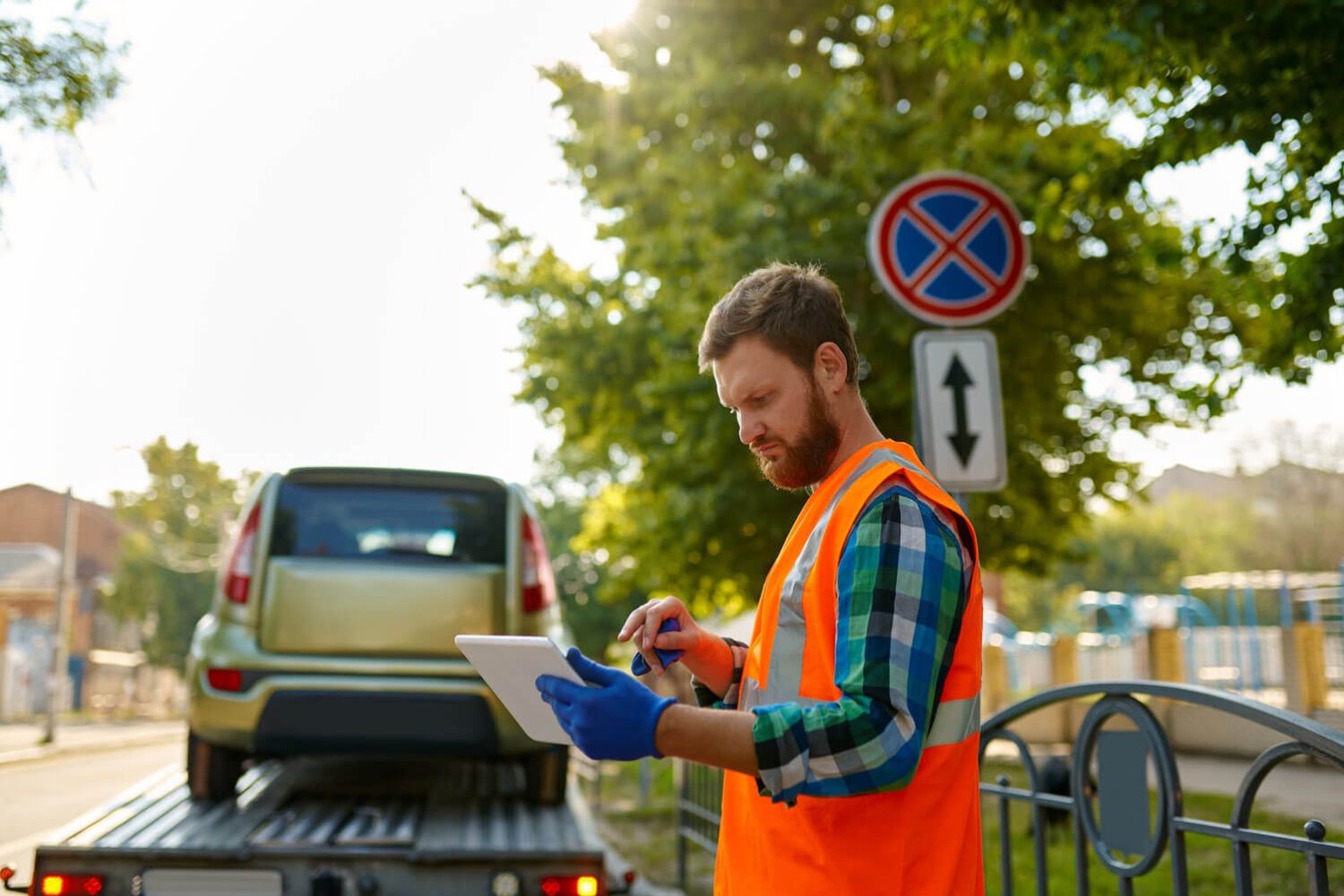 An image showing a man in a roadside assistance job role using a device